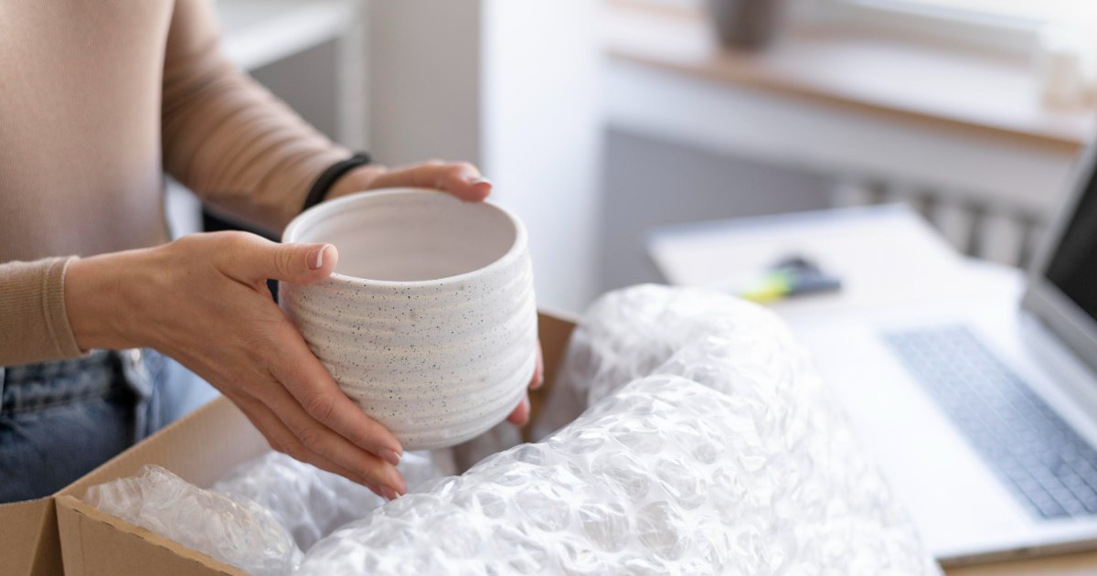 Donna che imballa vaso per un trasloco
